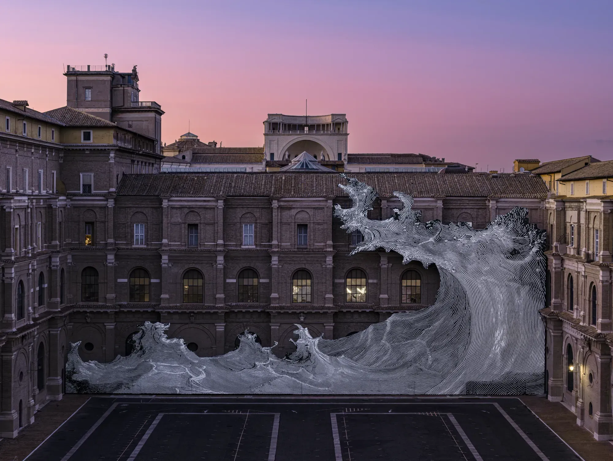 JR's black-and-white wave across the Vatican Apostolic Library facade at dusk, under a pink and violet sky, with a few windows lit behind it
