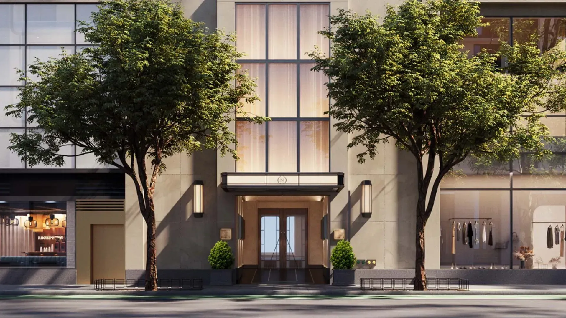 Rendering of a limestone entrance between two street trees, with a narrow canopy over bronze-framed glass doors, tall sconces either side and a backlit window above