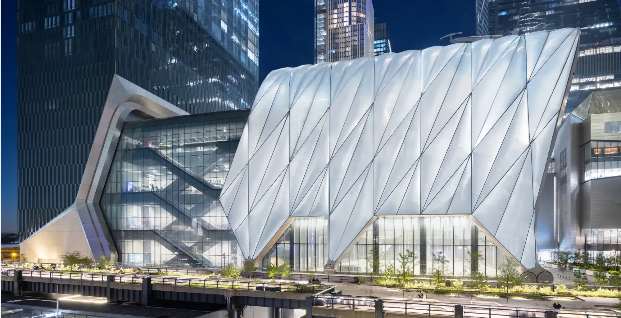 The Shed's Bloomberg Building at dusk, its quilted translucent shell lit from within above the High Line