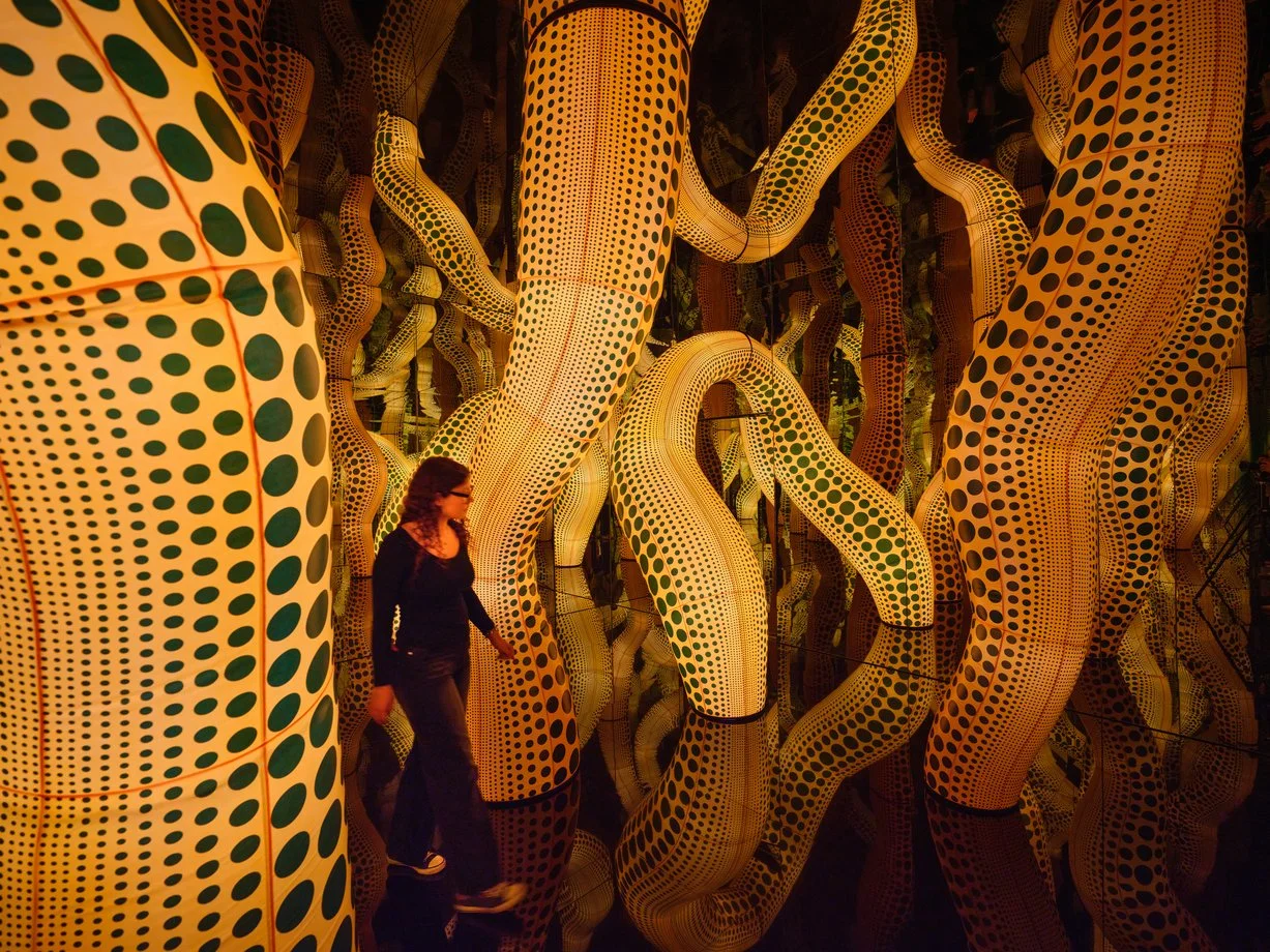 Mirrored room filled with glowing polka-dot spheres reflected infinitely